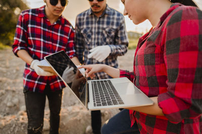 Woman discussing over laptop with male coworkers