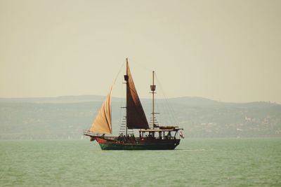 Sailboat sailing on sea against clear sky