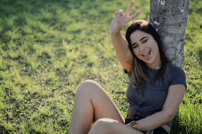 Beautiful young woman sitting on field