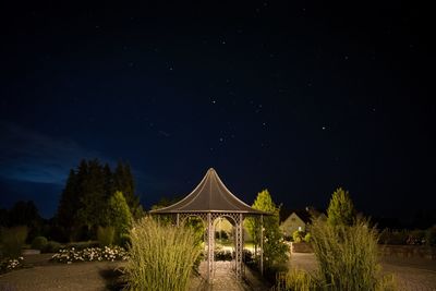 Built structure on landscape against sky at night