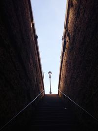 Low angle view of man standing on staircase against sky