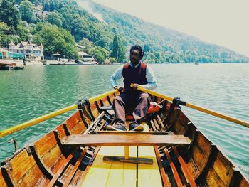 Rear view of man sitting on boat in sea