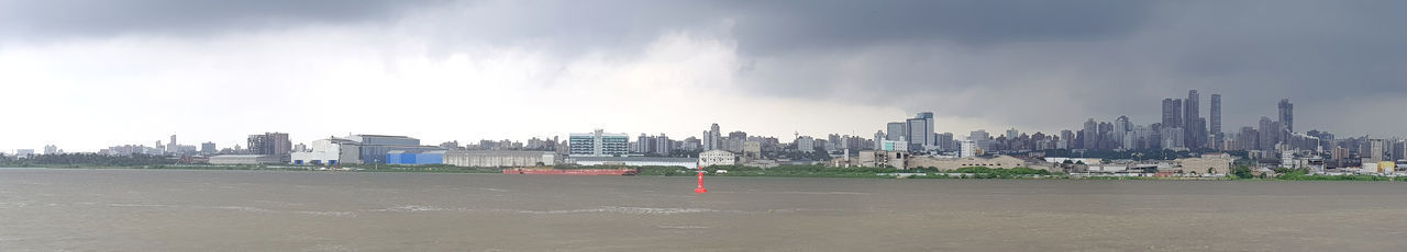 Panoramic view of city against cloudy sky