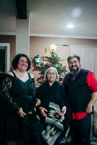 Portrait of family in front of christmas tree