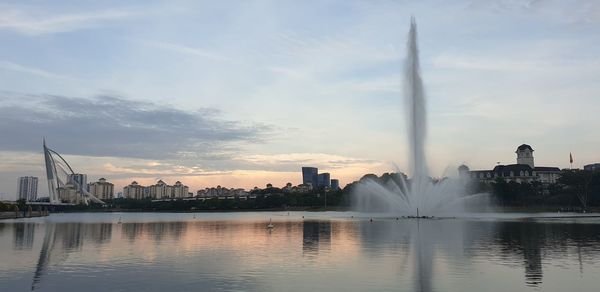 Modern buildings in city against sky during sunset