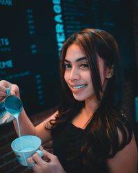 Portrait of a beautiful young woman drinking glass