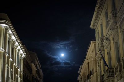 Low angle view of illuminated buildings against sky at night