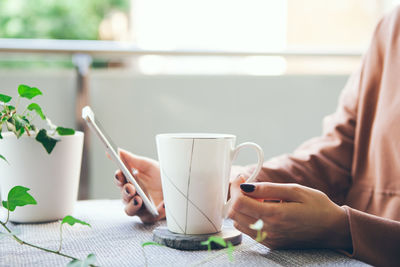 Man holding coffee cup on table