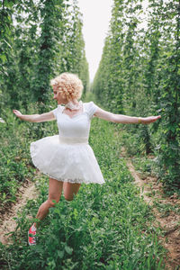 Full length of woman running on plants