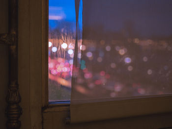 Close-up of illuminated window against sky at night