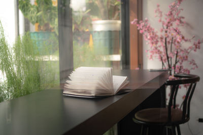 Close-up of open glass window on table