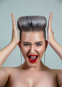 Portrait of beautiful woman against gray background