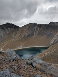 Scenic view of lake by mountains against sky