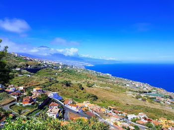 High angle view of houses by sea against sky