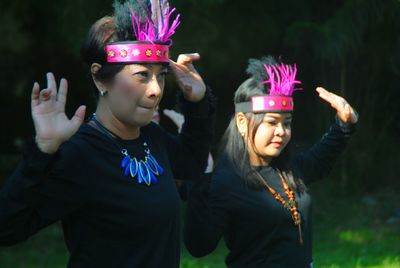 Young females dancing on grassy land