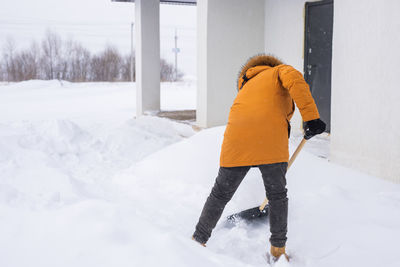 Full length of man standing on snow covered field