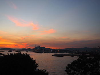 Scenic view of sea against cloudy sky during sunset