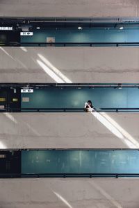 Mid distance view of woman photographing in building corridor