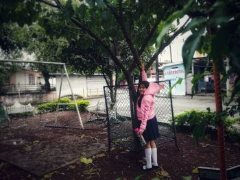 Woman standing by tree