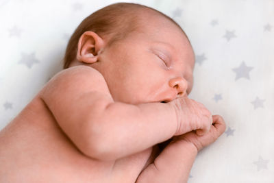 Portrait of newborn baby sleeping on white blanket.  a one weeks old infant is sleeping tightly