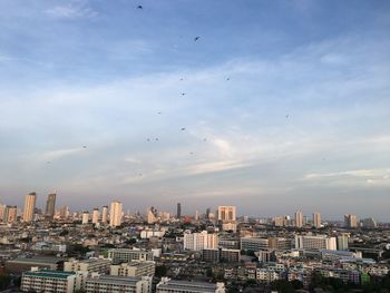 Aerial view of buildings in city against sky