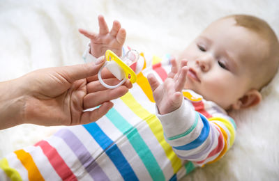 Baby girl playing with pacifier at home