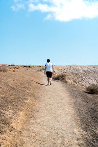 Rear view of man running on road