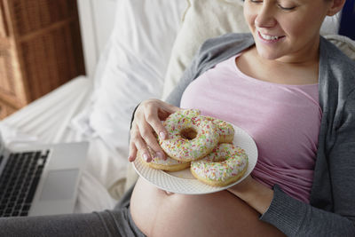 Midsection of woman holding ice cream at home