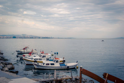 Boats moored in sea against sky