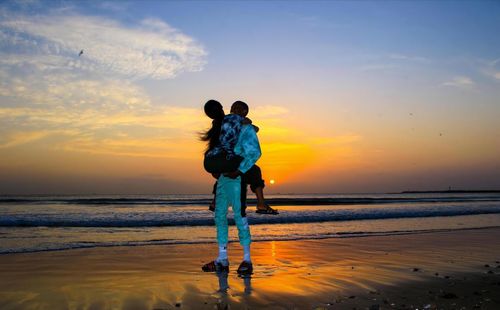 Full length of couple on beach during sunset