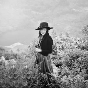 Beautiful woman smiling while standing amidst plant