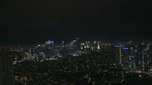 Illuminated cityscape against sky at night