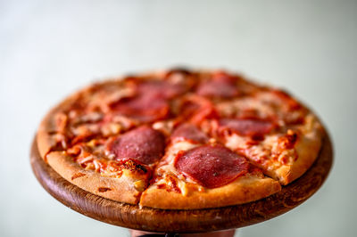 Close-up of pizza on table against white background