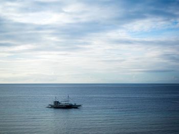 Lone boat in calm blue sea against sky