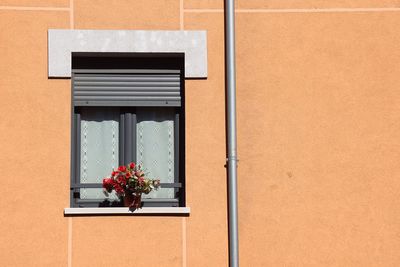 Window on the orange facade of the house in bilbao city spain