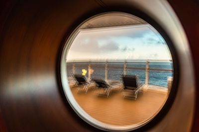 Reflection of clouds in sea seen through window