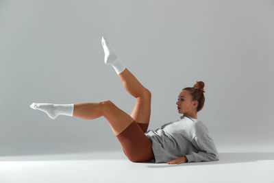 Rear view of woman with arms raised against white background