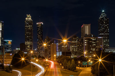 Illuminated buildings against sky at night