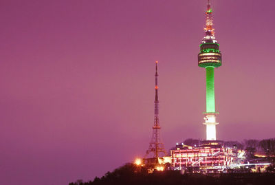 Low angle view of illuminated tower against pink sky