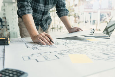 Low section of man working on table