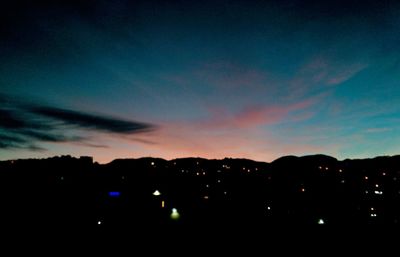 Silhouette city against sky at sunset