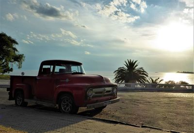 Vintage car on palm trees against sky