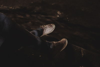 Low section of man wearing shoes while sitting outdoors