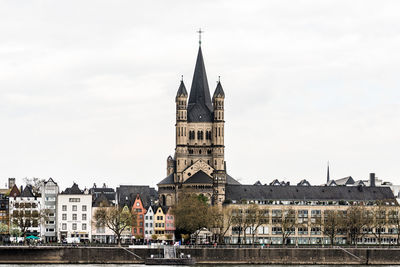 Clock tower in city against cloudy sky