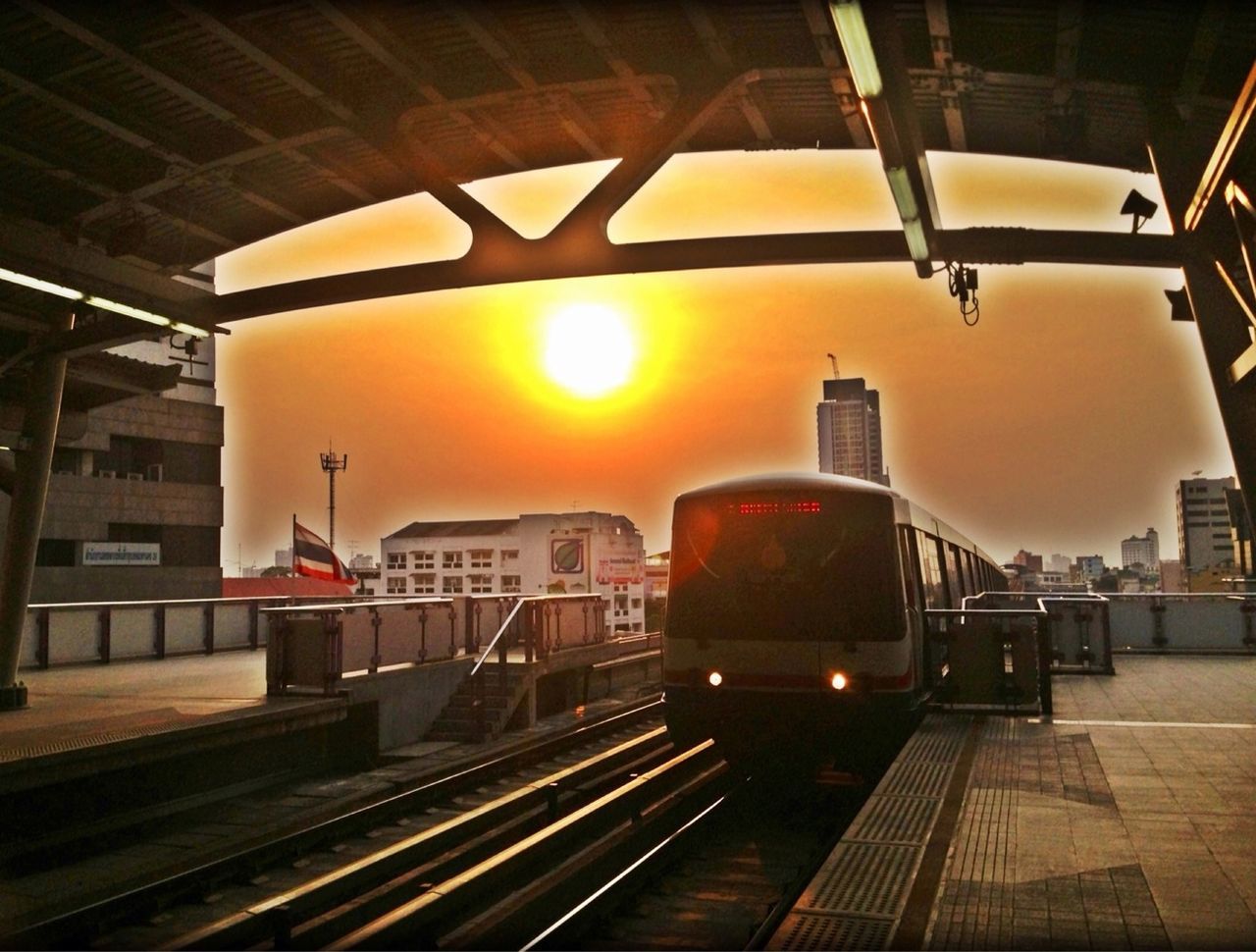 illuminated, railroad station, built structure, architecture, railroad track, rail transportation, public transportation, railroad station platform, indoors, lighting equipment, building exterior, transportation, ceiling, orange color, incidental people, railing, yellow, steps, subway station, steps and staircases