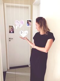 Woman standing against wall at home