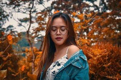 Portrait of beautiful young woman standing in autumn