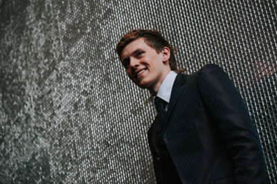 Handsome man standing against wall