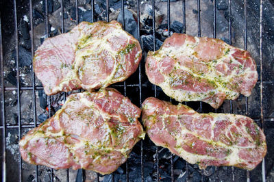 Directly above shot of pork cooking on barbecue grill