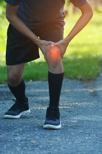 Low section of man standing on footpath